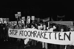 Demonstranten op het Binnenhof in het donker, met een spandoek met de tekst "Stop atoomraketten"